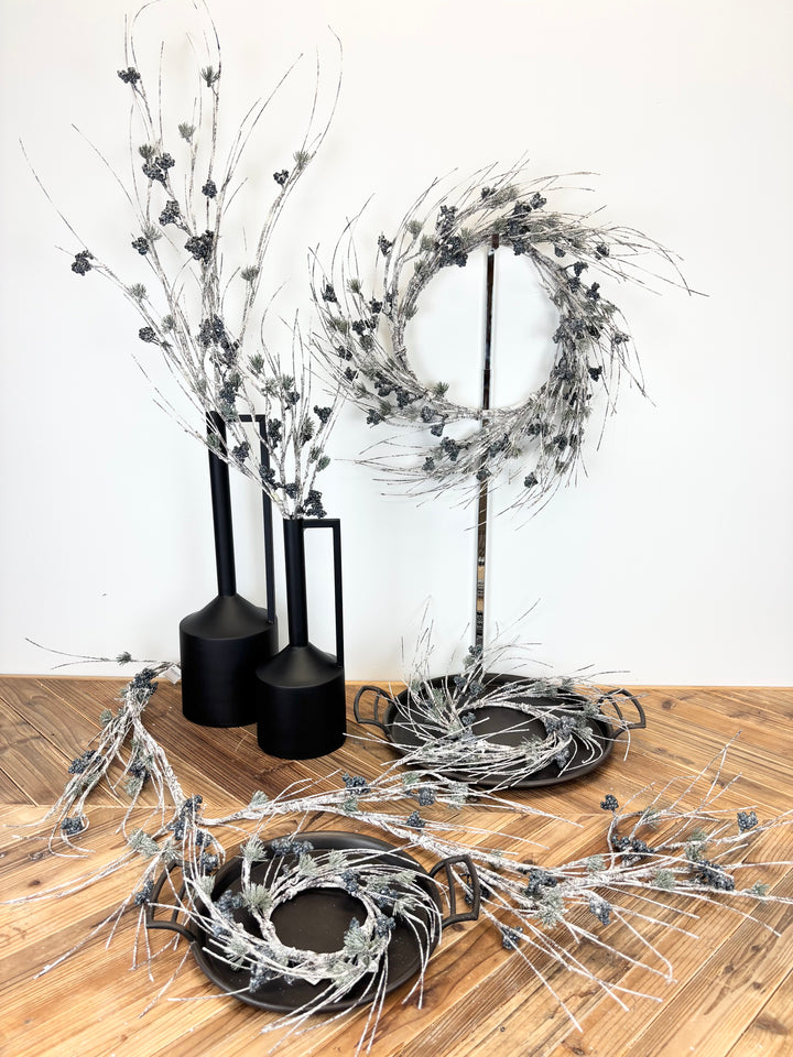 Decorative wreaths and branches on a wooden surface with a white background