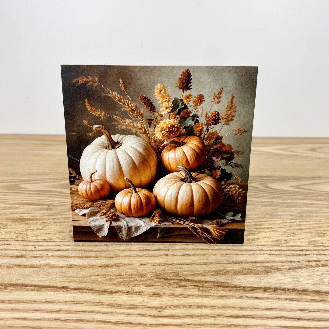 Decorative card with pumpkins and autumn foliage on a wooden surface