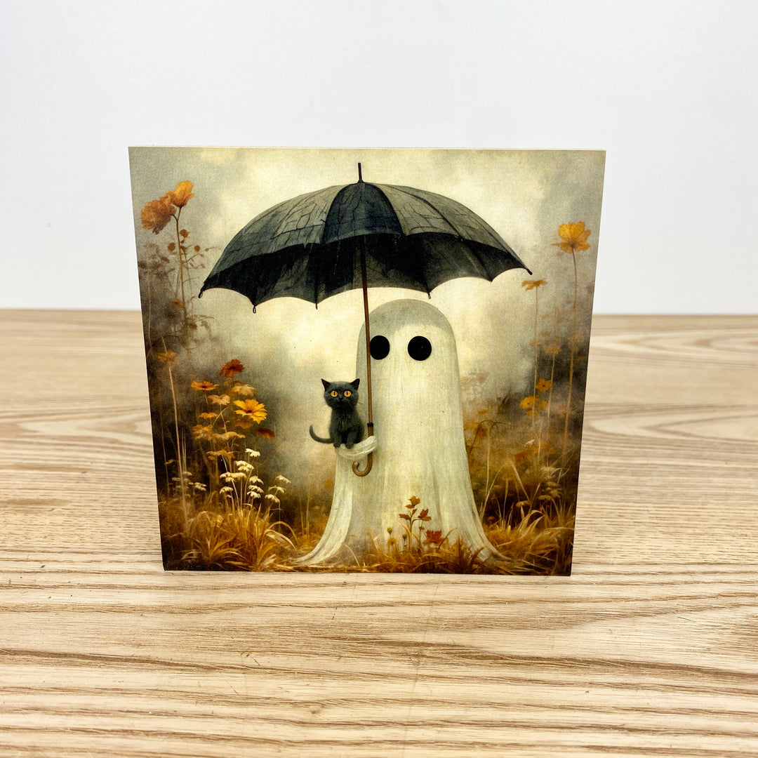 Ghost with an umbrella and a black cat in a field of flowers on a wooden surface