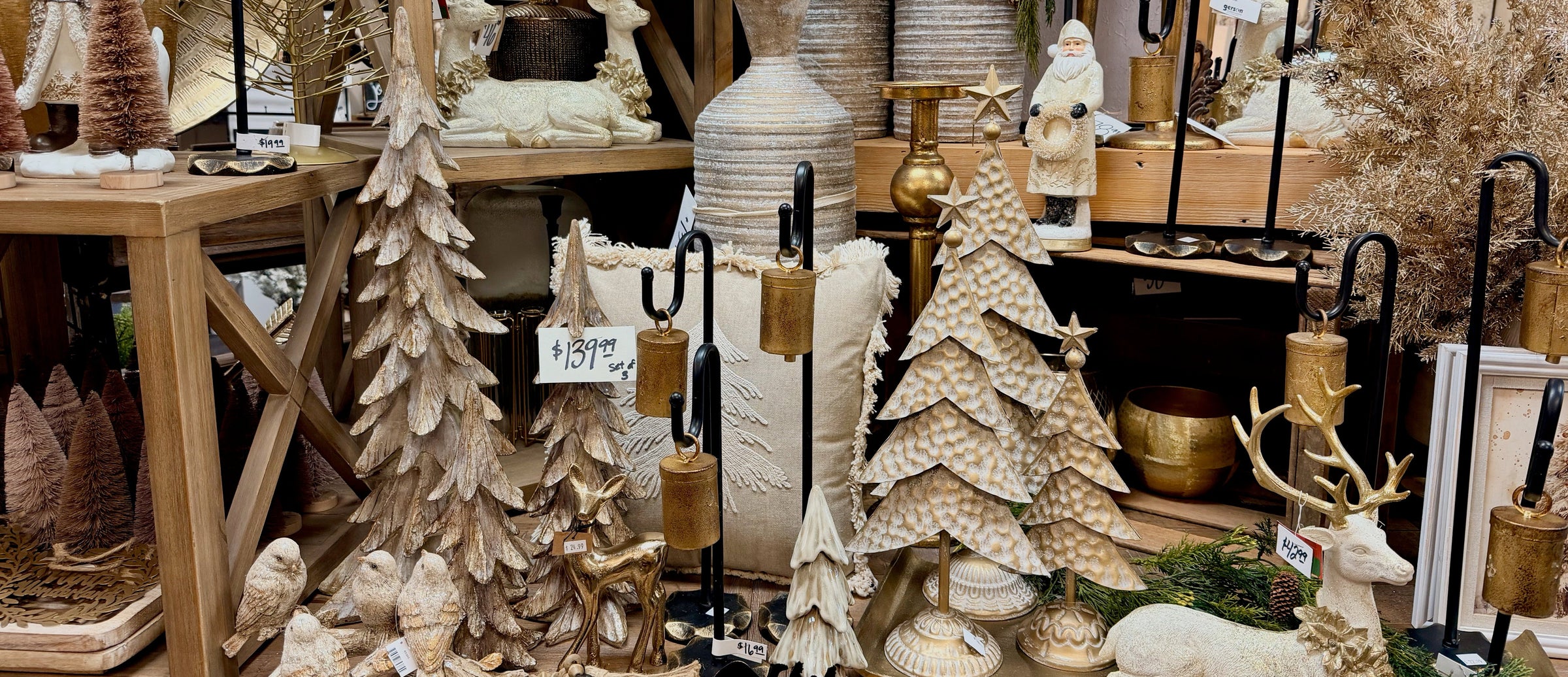 Display of decorative items including trees, deer, and vases in a store setting.