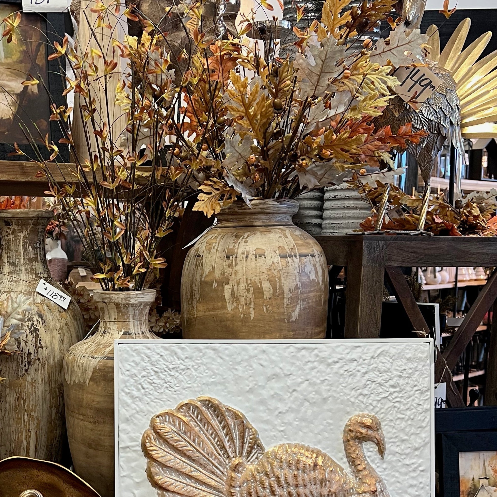 Decorative items including vases, candles, and a turkey-themed painting in a store setting.